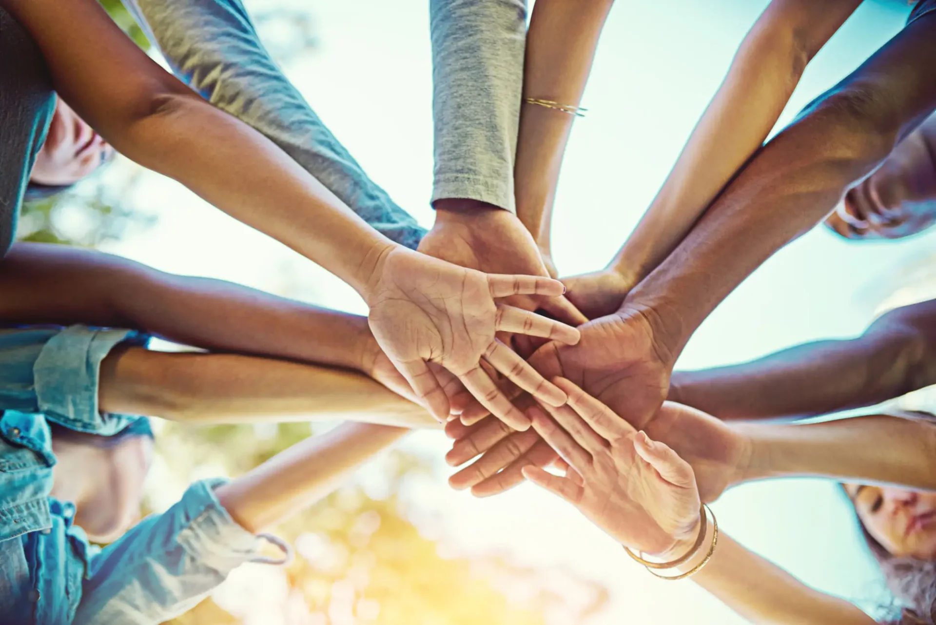 Multiple hands stacked together symbolizing unity and teamwork.