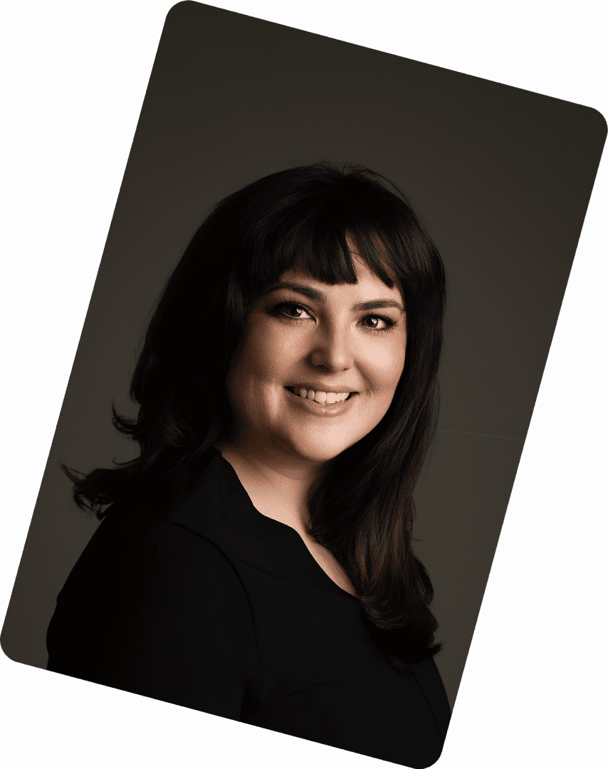 Professional portrait of a smiling woman with dark hair and bangs.