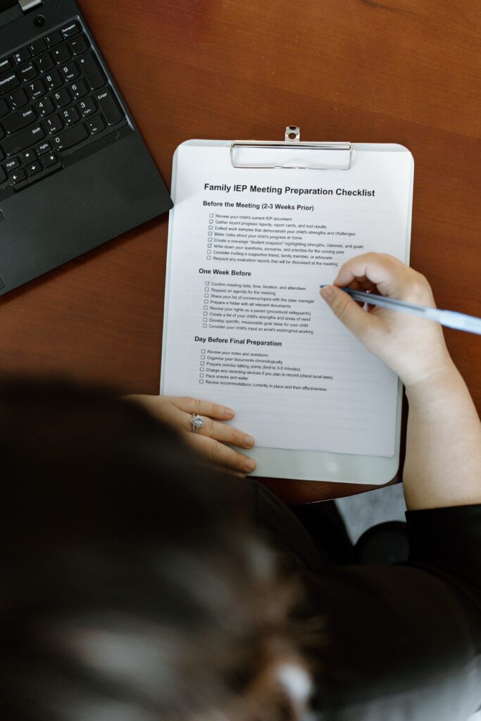 Person filling out a Family Self-Monitoring Food Diary form with a pen.